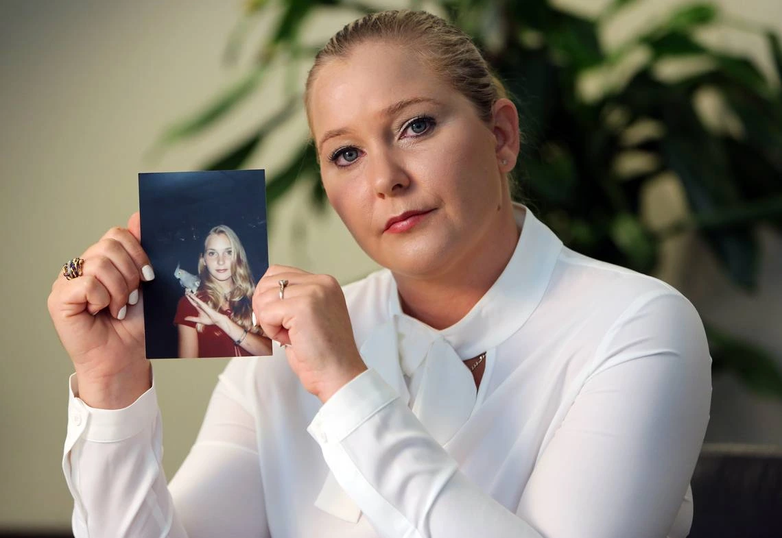 Virginia Roberts holds a photo of herself at age 16.