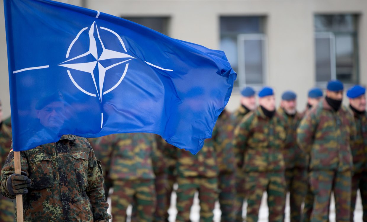 A German soldier hoists the NATO flag