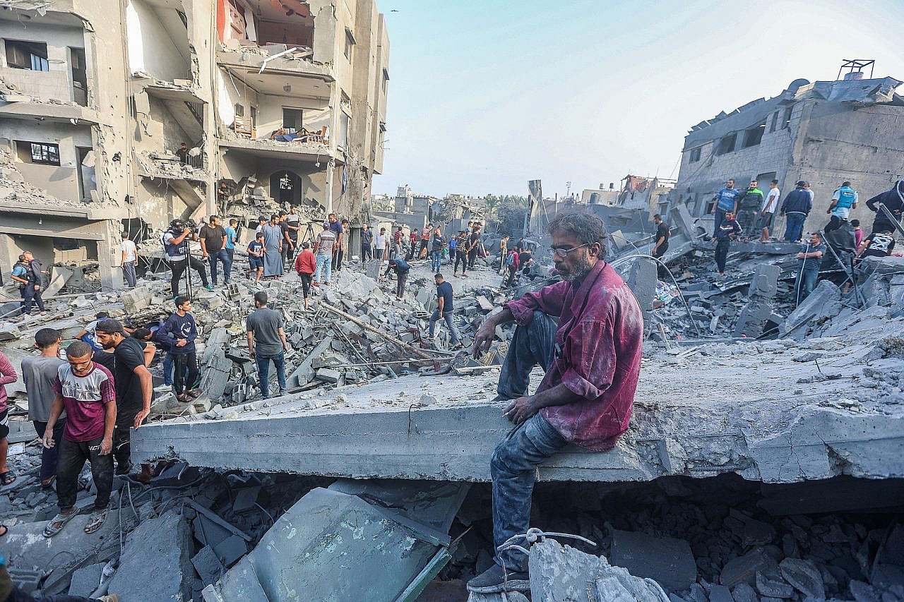 Palestinians at the rubble of a destroyed building