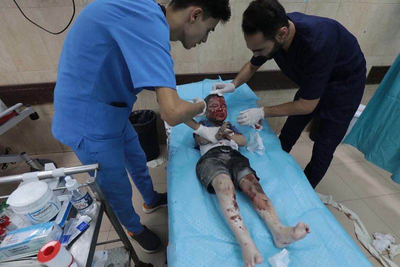 Palestinian medics treat a wounded child