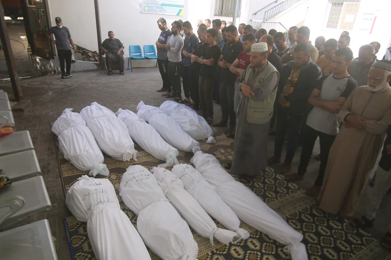 Mourners pray during a funeral for Palestinians