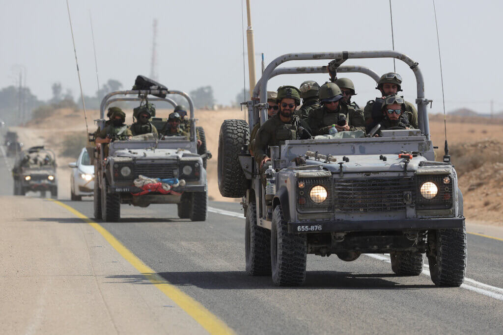 Israeli soldiers drive along the border with Gaza