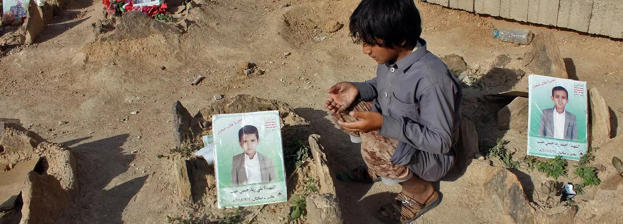 Yemeni boy says a prayer for other children killed in bus attack